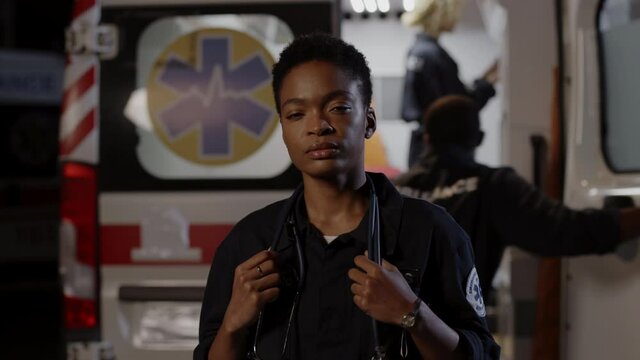 African american paramedic standing outdoors near ambulance