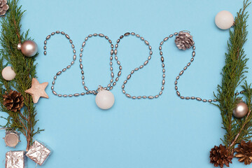 Christmas, New Year flat lay on blue background. Numbers 2022 making. Top view. Copy space. Mock...