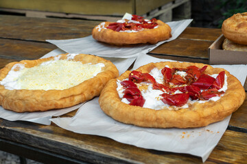 Langos with different toppings on wooden table. Langos - deep-fried flatbread, traditional hungarian food. Budapest, Hungary.