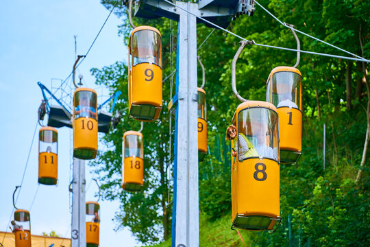 Aerial lift for tourists, yellow cable cars, transport from mountain to sea beach