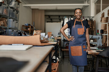 Smiling African female leather worker standing in her studio