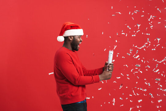 Black Man In Christmas Hat Screaming While Blowing Up Party Popper
