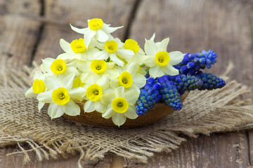 spring flowers bouquet in a vase on wooden background