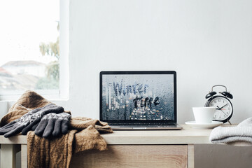Winter background concept with winter time inscription on laptop screen