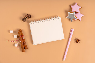 Christmas background with blank white notebook surrounded by Christmas decorations. Letter to Santa or Christmas shopping list. Top view, copy space
