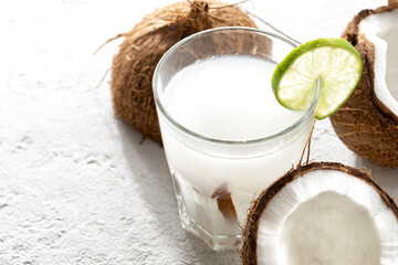 Fresh coconut water in glass cup on light background witth copy space