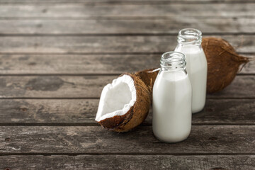 Coconut milk in bottles on wooden table with copy space.  Healthy eating concept