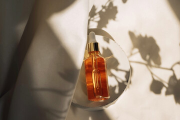 Unbranded bottles in mockup style on podium with shadow top view. Tube of eye oil on a white background. Beauty background with facial cosmetic products. Spa, beauty concept.
