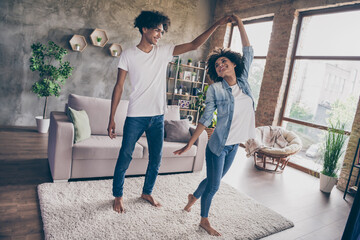 Full length photo of young dark skin couple dance good mood in living room flat apartment indoors house