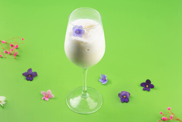 milk shake white cocktail in glass with berries and flowers