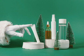 Unbranded bottle with dispenser on geometric podium. Santa's hand touches day cream cosmetic oil,...