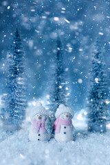 toy snowmen with a Christmas tree in a snowy forest