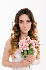 a happy girl in white dress with bouquet. Love and spring blooming. Isolted on white background. Bride in studio