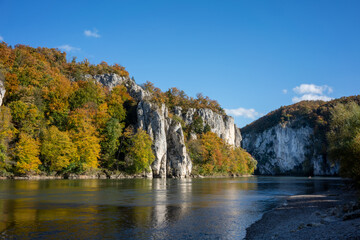 Felsenpanorama vor der Donau im Oktober mit bunter Laubfärbung mit Kajak gegenüber Kloster Weltenburg