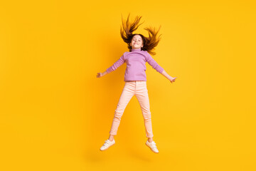 Fototapeta na wymiar Full length body size view of attractive cheerful girl jumping having fun good mood isolated over bright yellow color background