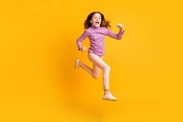 Full length body size view of attractive motivated cheerful girl jumping running isolated over bright yellow color background