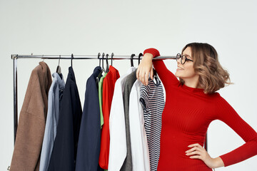 pretty woman with glasses next to clothes fashion fun isolated background