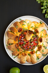 Homemade Pull Apart Flauta Ring on a plate on a black background, top view. Overhead, from above, flat lay.