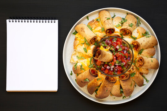 Homemade Pull Apart Flauta Ring on a plate, blank notepad on a black background, top view. Overhead, from above, flat lay.