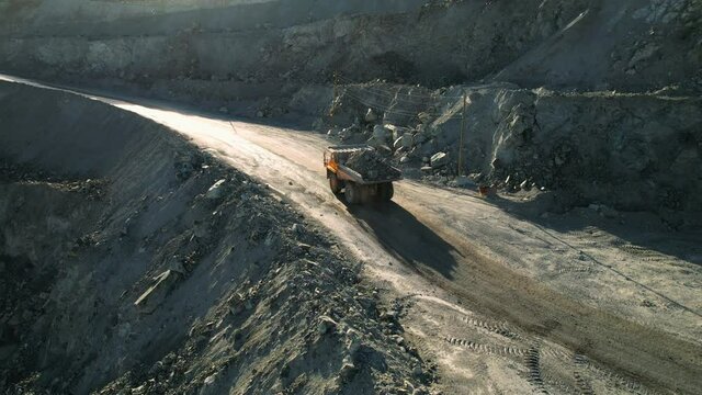 Open pit iron ore mining, a big yellow mining truck at work, working in a quarry, big yellow heavy truck in open cast mine, mining of iron ore, the overall plan, Dump Truck, sunny day