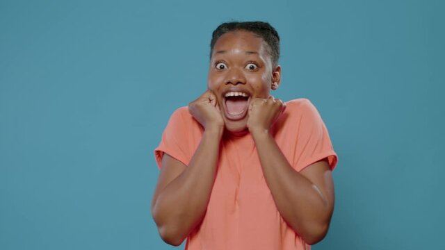 Excited woman hearing good news and feeling surprised in front of camera. Close up of amazed person finding unexpected surprise and showing stupefied facial expression with mouth open.