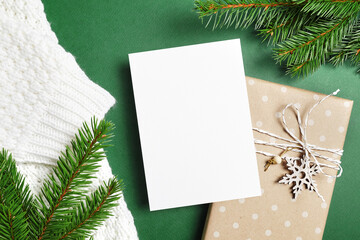 Fototapeta na wymiar Christmas or New Year greeting card mockup with decorated gift box and fir tree branches