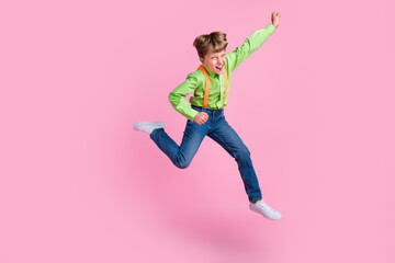 Fototapeta na wymiar Full length body size view of attractive cheerful trendy lucky boy jumping rejoicing isolated over pink pastel color background