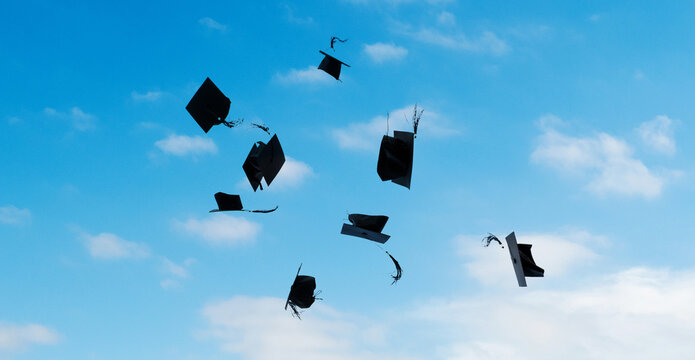 Group of graduation caps thrown in the air