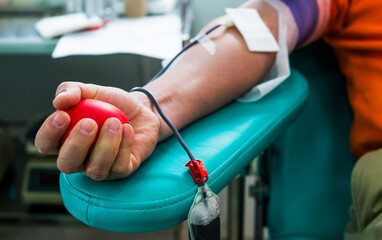 Blood donor at donation with bouncy ball holding in hand