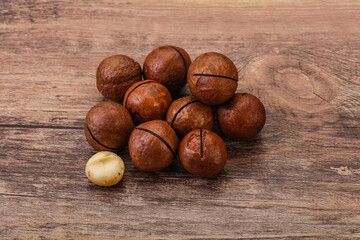 Brown macadamia nut heap over background