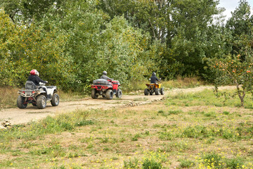 A peloton of tourists on quadrocopters moves along the route along a country road. Copy space.