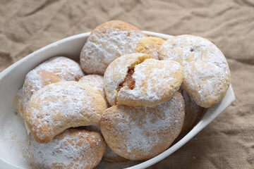 Traditional homemade cookies filled with jam in a white baking tray. Typical italian pastry.