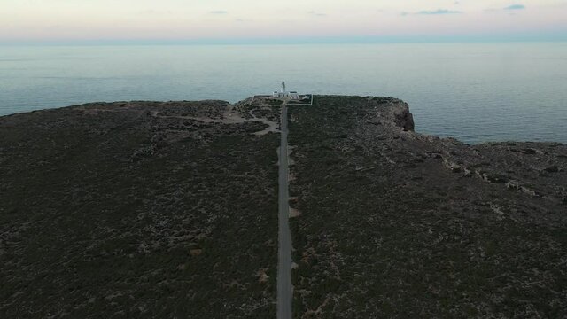 Beautiful lighthouse surrounded by water in Menorca island, Balearic Islands, Drone. Punta Nati Lighthouse.