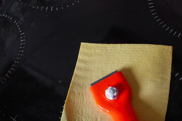 Scraper for cleaning glass ceramics and a rag for wiping glass ceramic slab panels