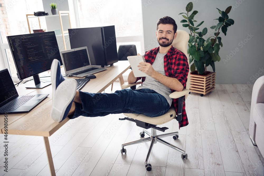 Sticker Full body photo of happy young cheerful man write notebook good mood coder pc sit table indoors inside office