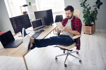 Full length photo of serious young man sit desk write notebook programmer coder indoors inside...