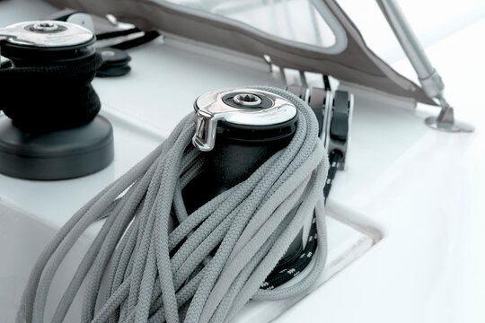 Nautical yachting Rope winch with gray and black ropes or lines on yacht, sail boat, white board deck