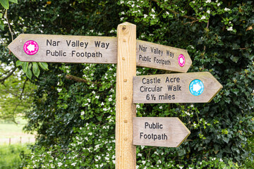 Public footpath signpost for the Nar Valley Way and the Castle Acre Circular Walk at Castle Acre, Norfolk UK
