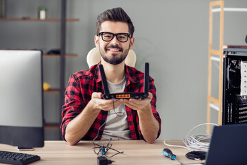 Portrait of attractive cheerful skilled trendy guy fixing repairing rout line service at office...