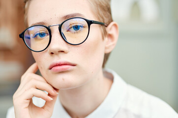 student with glasses walking around the city with a book education