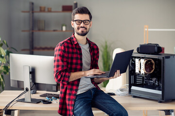Portrait of attractive qualified guy senior designer dev ops manager using laptop designing at office work place station indoor
