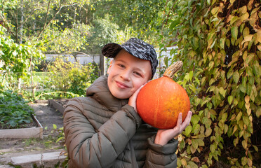boy with orange pumpkin in his hands