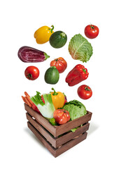 Vegetables flying in wooden box isolated from the background