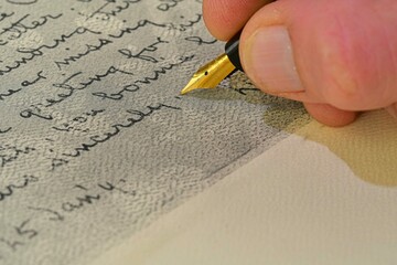 Close-up of a male hand ready to write with an elegant fountain pen. Handwriting - writing with a...