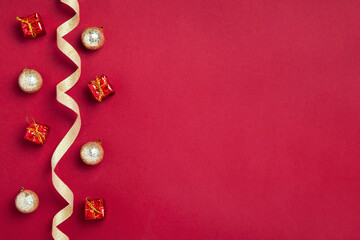 Fototapeta na wymiar New Year or Christmas border or background with golden ribbon, golden balls and gifts on red background, copy space. Mockup for postcards, business cards and other festive materials