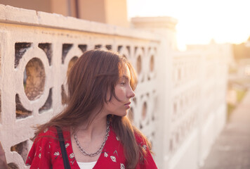 Portrait of a sad teenager girl is dreaming  outdoors at summer evening