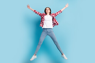 Full body photo of cool millennial brunette lady jump wear red shirt jeans isolated on blue color background