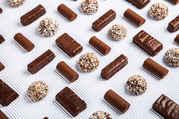 Assorted chocolate candies on wooden background. Chocolate sweets. Dessert background.