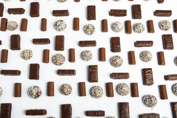Assorted chocolate candies on wooden background. Chocolate sweets. Dessert background.