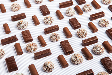 Assorted chocolate candies on wooden background. Chocolate sweets. Dessert background.